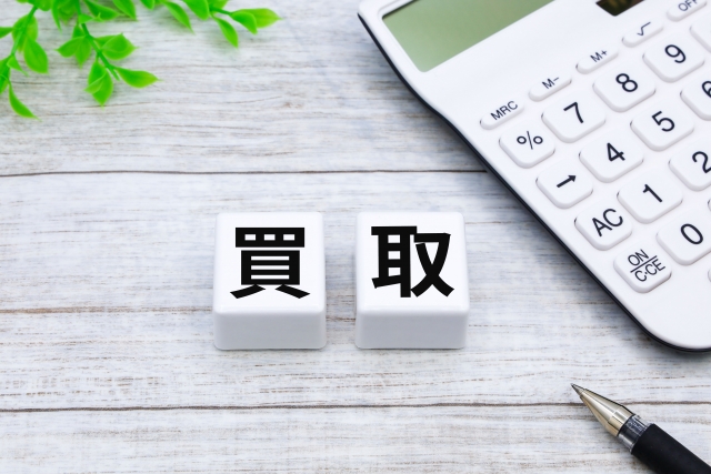 買取の文字が書かれた積み木と計算機