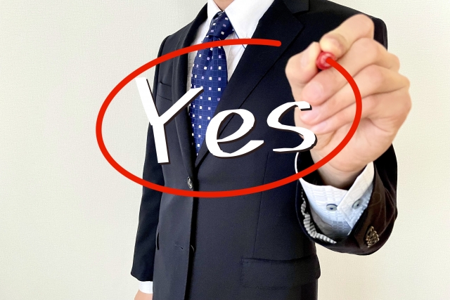 Yesを赤ペンで囲む男性