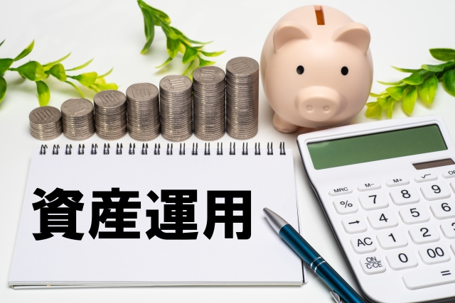 資産運用の文字列かか書かれたノートと計算機